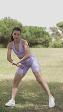 Sportif bir kadın şehir parkında dans eder.
