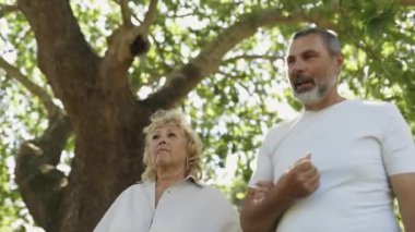 Erkek ve kadın güneşli bir günün tadını çıkarıyorlar parkta sakin bir gezinti için.