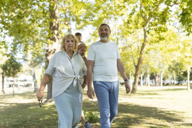 Aile, üç nesildir güneşli bir parkta rahatça geziniyor.