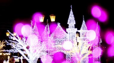 Beyaz noel şatosu güzel aydınlatılmış mor bokeh ışıklarıyla.