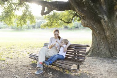 Anne ve oğlu parkta bir bankta birlikte bir şeyler atıştırıyorlar. Yürek ısıtan bir bağ kuruyorlar.
