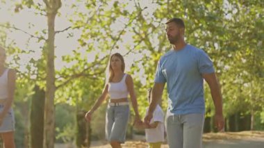 Aile parkta birlikte yürümekten hoşlanıyor.