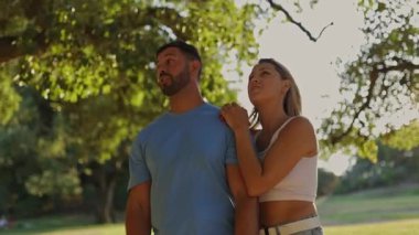 Romantik çift parkta keyifli bir gezinti yapıyor, eğlenceli bir ağaca tırmanma macerasıyla sonuçlanıyor.