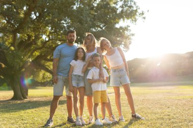 Sıcak bir öğleden sonra güneşli bir parkta aile bağı.