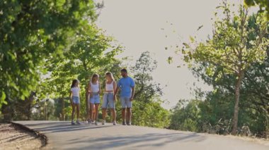 Aile, parkta rahatça yürüyüp, el ele tutuşup, kalıcı anılar yaratıyor.