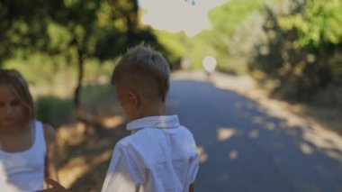 Erkek ve kız kardeş parkta sözsüz iletişim kurarak çocukluk anılarını canlandırıyor.