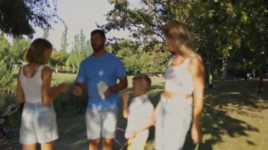 Aile üyeleri güzel bir parkta piknikten sonra temizlik yapıyorlar.