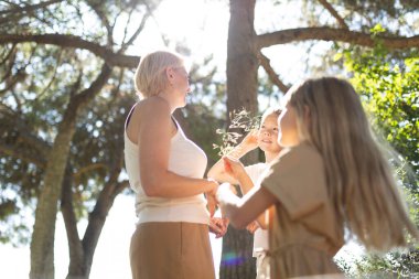 Aile güneşli ormanda birlikte doğanın tadını çıkarıyor.