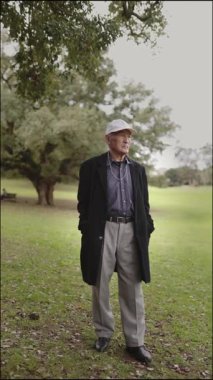 Kıdemli adam yemyeşil bir parkın içinde huzurlu bir anın tadını çıkarıyor.