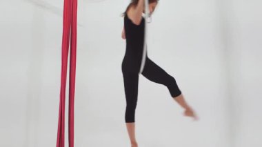 Jimnastik. Havada asılı duran çemberde dönen genç bir kadın. Orta çekim