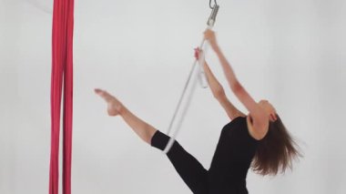 Hava jimnastiği. Havada asılı duran çemberde dönen genç bir kadın. Orta çekim
