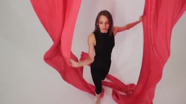 Hava jimnastiği. Stüdyoda bir parça bezle dans eden genç bir kadın. Orta çekim