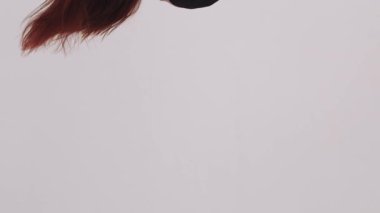 Hava jimnastiği - ince jimnastikçi kadın baş aşağı asılı duran pembe bez parçasıyla egzersiz yapıyor. Orta çekim