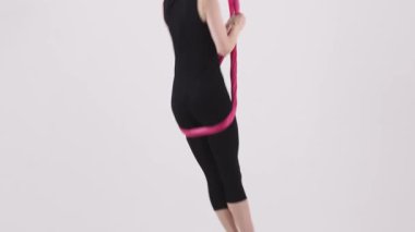 Genç akrobat kadın hava jimnastiği sırasında kumaş dengesi kurar. Orta çekim