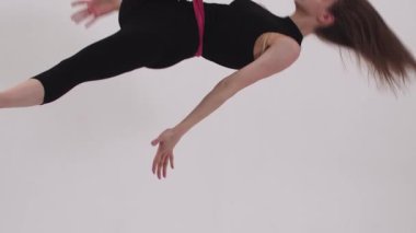 Genç ince akrobatik kadın havadan jimnastik yaparken kumaş dengesi kuruyor. Orta çekim