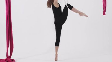 Hava yogası. Tavanın altında asılı duran çemberde dönen genç bir kadın. Orta çekim