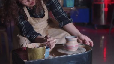 Çömlekçilik. Kıvırcık saçlı kadın. Yeni çömleğe renk katıyor. Orta çekim