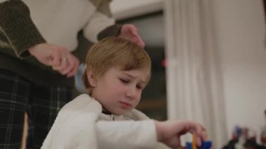 Anne banyodan sonra oğlunun saçını tarıyor.