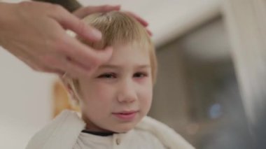 Sürecin çeşitli aşamalarını gösteren bir çocuğun ebeveyninden saç tıraşı olması görüntüsü