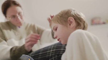 Annem evde sarışın çocuğuna saç kesiyor.