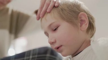 Çocuk saçını evde kestirirken üzülüyor