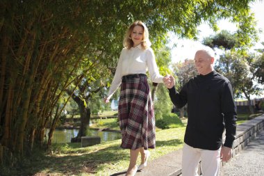 Mutlu, olgun bir çift el ele tutuşup funchal, madeira 'da güzel bir tropikal bahçede yürüyor.