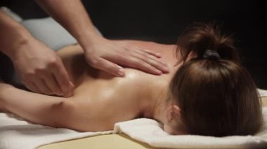 Profesyonel masör, masaj masasındaki kadınlara masaj yapıyor.
