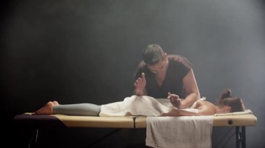 Bir kadına masaj yapan profesyonel bir masör.