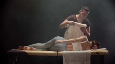 Profesyonel masör kaplıcadaki kadına sırt masajı yapıyor.