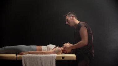Profesyonel osteopat genç bir kadına boyun manipülasyonu yapıyor.