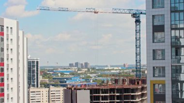 Bir inşaat alanında faaliyet gösteren vinç, kentsel kalkınma projesi için malzeme kaldırma