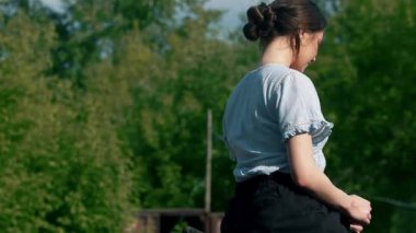 Ata binme eğitimi, tekerleklerin yanında ata binen genç bir kadın...