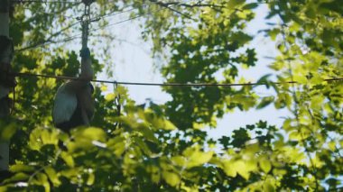 İp ve kütük inşaatından geçen bir kadın. Yeşil parktaki eğlence merkezi. Orta çekim