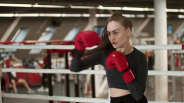 Boks ringinde uzun saçlı çekici bir genç kadın. Orta çekim