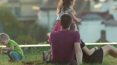 Güneşli akşam, telefoto parkta çocuklu genç aile vurdu