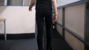 Artistik patinajcı bir kız halka açık buz pistinin kapısına doğru yürüyor. Orta çekim