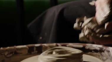 Çömlekçi çarkında ıslak kille çalışan bir adam. Orta çekim