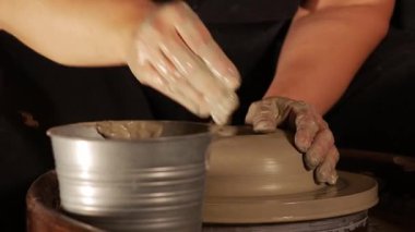 Direksiyonda ıslak kille çalışan yaşlı bir kadının elleri. Orta çekim