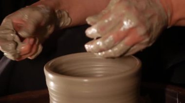 Çamur tenceresinin kenarını şekillendiren kadın elleri. Orta çekim