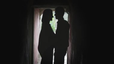 Romantik çift loş bir sokakta hassas bir anı paylaşıyor, siluetleri yakınlık ve gizem hissi yaratıyor.