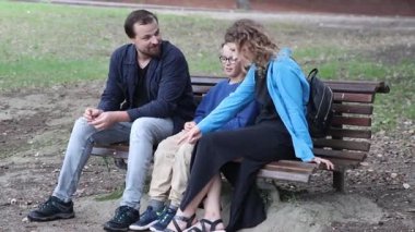 Ebeveynler çocuklarının bir bankta otururken ayakkabı bağcıklarını bağladığını görüyorlar.