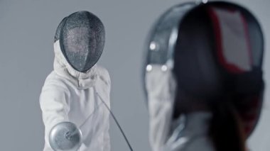 Eskrim - iki genç kadın eskrim antrenmanı yapıyor. Orta çekim