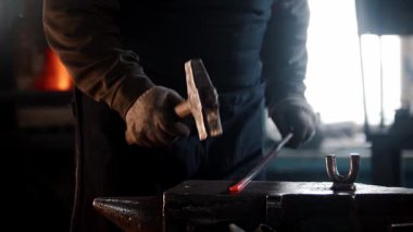 Demirci örse kızgın metal vuruyor.