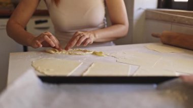 Pasta şefi elmalı turta hazırlıyor, mutfak masasında hamur şekillendiriyor.