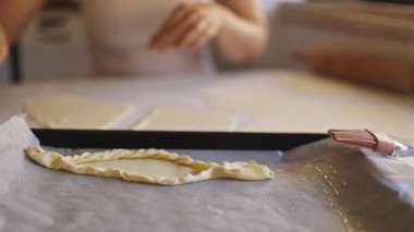 Ev mutfağında turta kabuğu hazırlayan bir kadın.