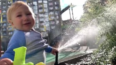 Su jeti tutan ve oyun parkında oynayan mutlu çocuk.