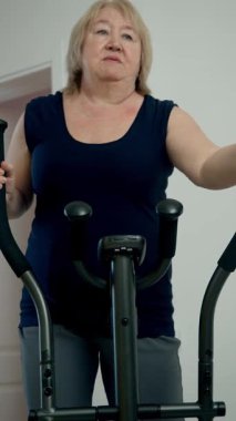 Yaşlı bir kadın spor yapıyor, aktif yaşam tarzının tadını çıkarıyor.