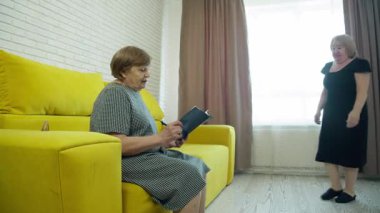 İki yaşlı kadın, bir kitap okurken, neşe ve bağın kıvılcımları saçan, yürek ısıtan bir anı paylaşıyor.