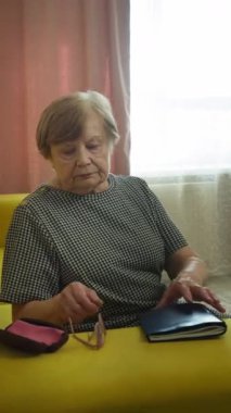 Kıdemli kadın oturma odasında kitap okumaya hazırlanıyor.