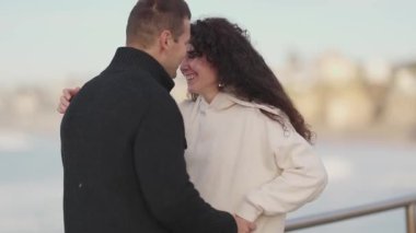 Genç çift deniz kenarında sevgi dolu anları paylaşıyor, birbirlerine eşlik ederek eğleniyorlar.
